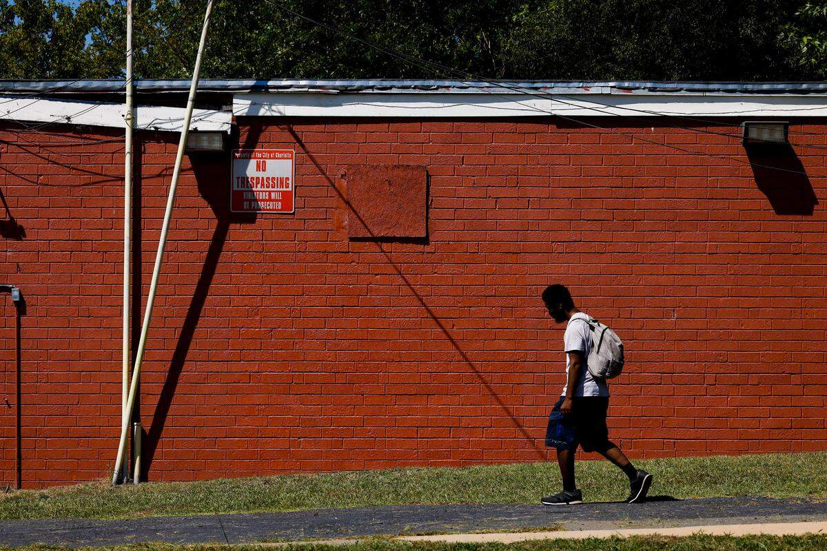 Johnny Alston, of Durham, walks past a mural from artist Kyle Holbrook which was recently covered by the building owner of Parkwood Food Mart who says the mural was applied without permission, in Charlotte, N.C., Thursday, Sept. 1, 2022.
