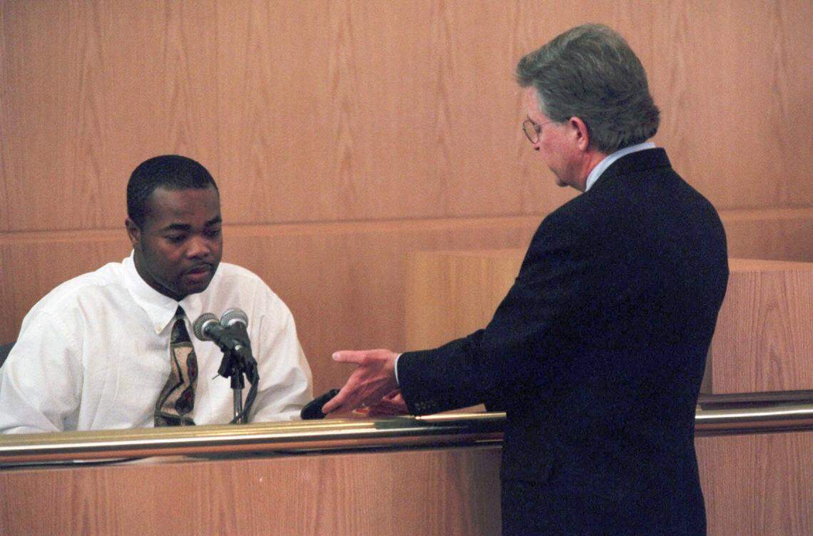 Co-defendant Michael Eugene Kennedy, left, is shown a handgun by prosecutor David Graham during his testimony. Kennedy testified  he had acquired the gun for $100, and it was used later the same night by Van Brett Watkins to shoot Rae Carruth’s pregnant girlfriend, Cherica Adams.