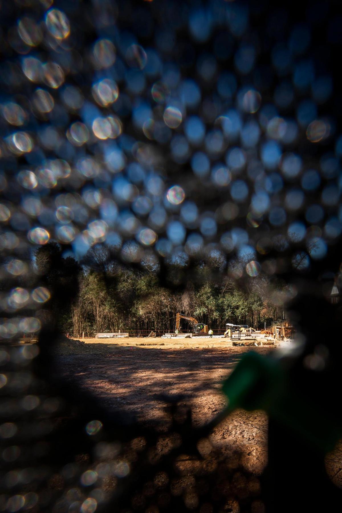Construction, seen through a tear in the fence, at the site of the former Wohlford House along Providence Road in Charlotte, N.C. Monday, Feb. 14, 2022. The historic property recently served as McEwen Funeral Home & Cremation was demolished to make way for a new Chase Bank.