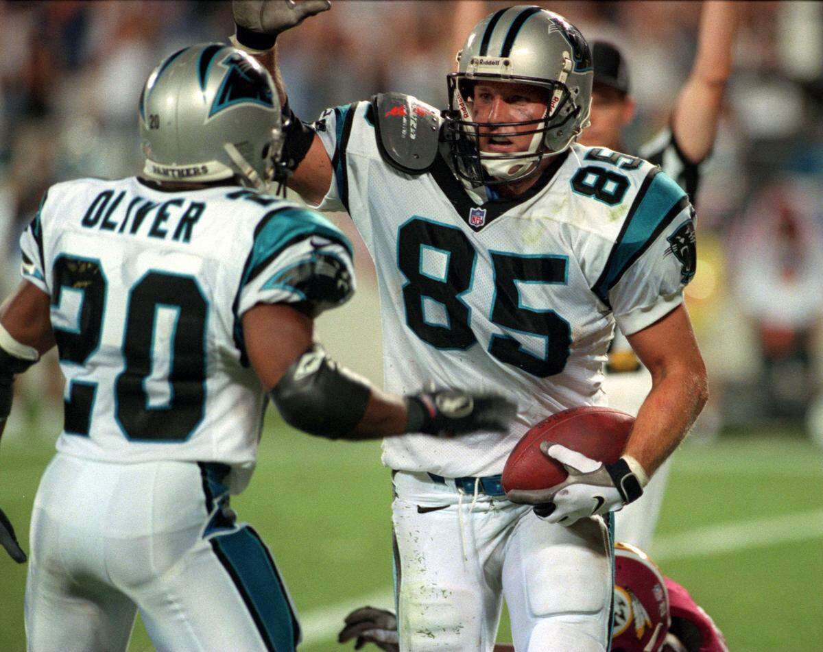 In 1997, Carolina’s Winslow Oliver (20) greeted tight end Wesley Walls after Walls had scored a touchdown.