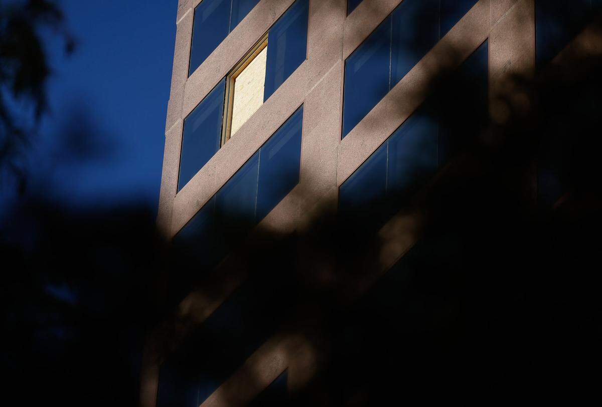 A plywood board covers a window that was shattered by a bullet on 16th-floor window of Wells Fargo building uptown Charlotte on Tuesday.