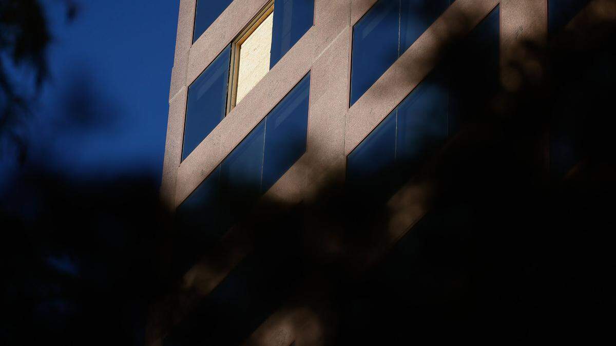 A plywood board covers a window that was shattered by a bullet on 16th-floor window of Wells Fargo building uptown Charlotte on Tuesday.