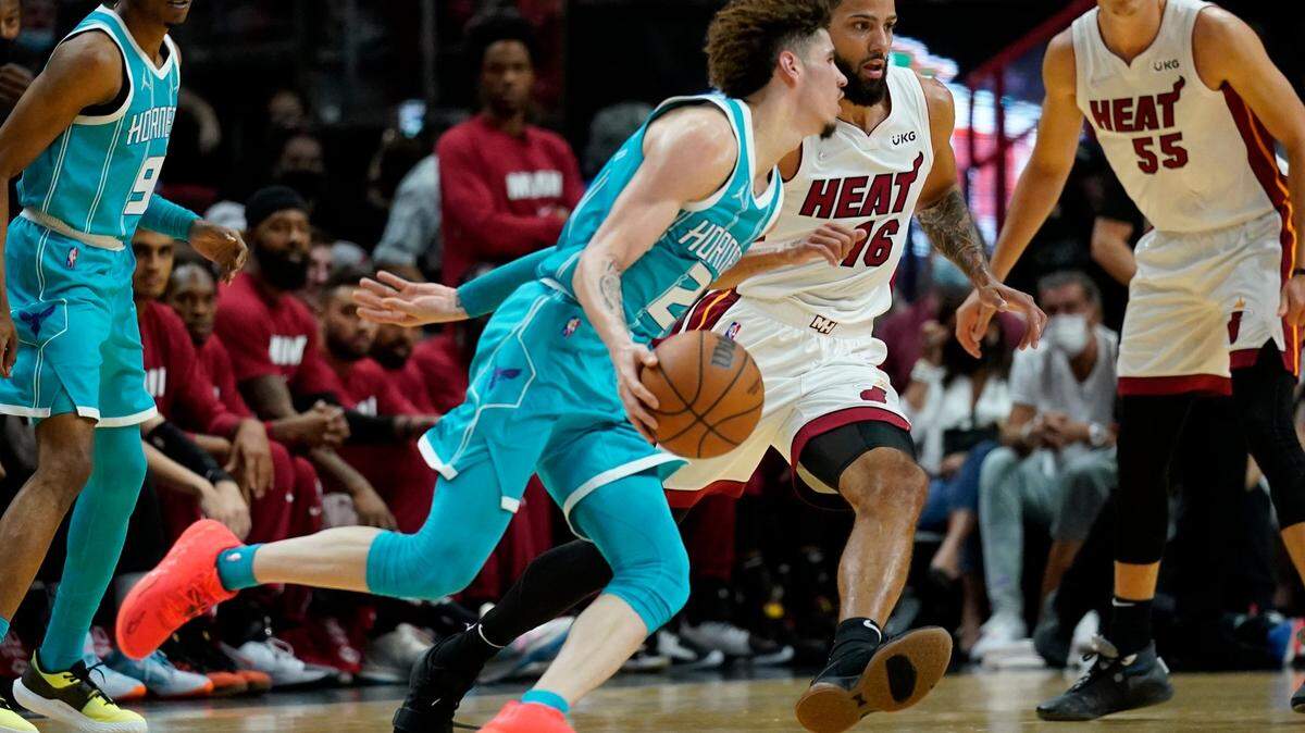 Charlotte Hornets guard LaMelo Ball (2) drives to the basket as Miami Heat forward Caleb Martin (16) defends during the first half of a preseason NBA basketball game, Monday, Oct. 11, 2021, in Miami. (AP Photo/Lynne Sladky)