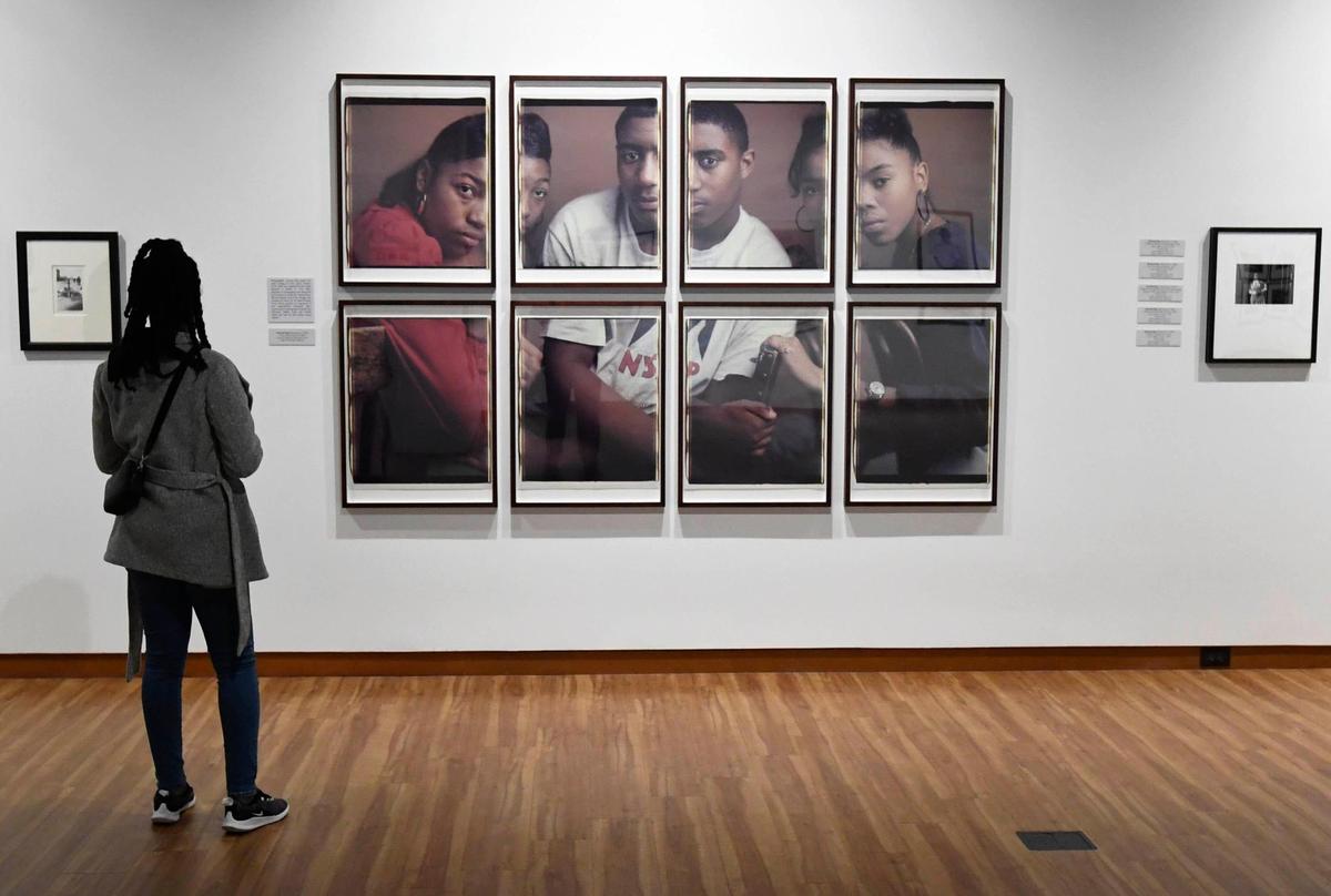A viewer looks upon a photo art installation called Toyia, Kelvin, & Erica II by Dawoud Bey as part of the “Vision & Spirit: African American Art” exhibit from the Bank of America collection at the Harvey B. Gantt Center for African-American Arts + Culture, which runs through July 31.