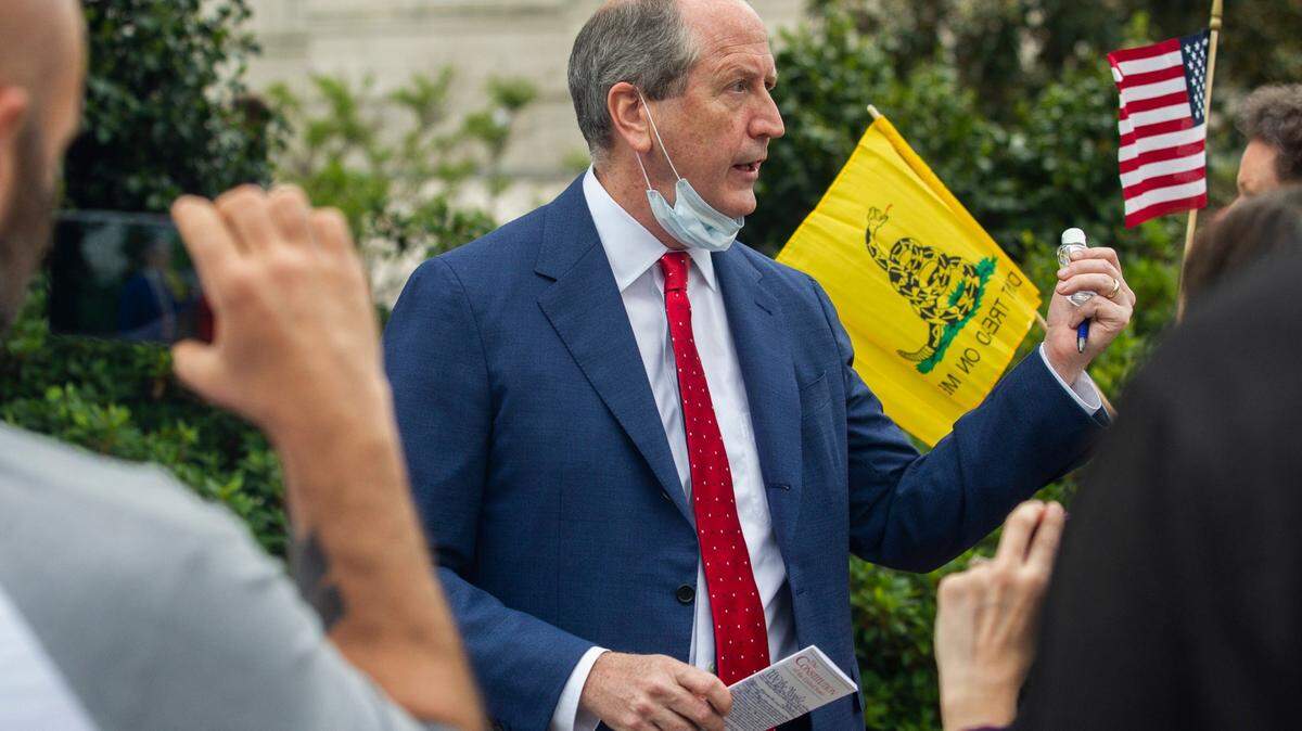 Rep. Dan Bishop holds a copy of the Constitution and a bottle of hand sanitizer while talking with constituents and reporters during a ReOpen NC protest in downtown Raleigh on Tuesday, April 21, 2020.