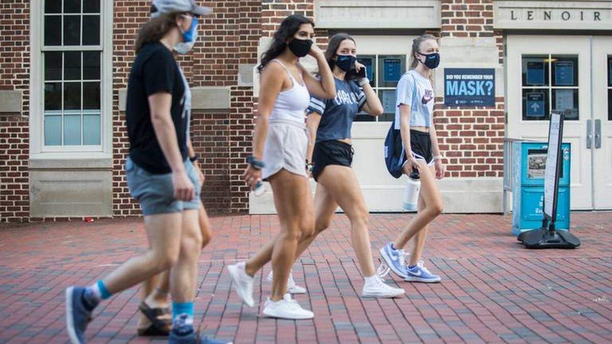 Students at UNC-Chapel Hill walk past Lenior Dining Hall in August. UNC was one of the first major universities in the nation to bring students back to campus for the fall semester. But just one week later, the university moved classes online and told students to move out of dorms because of COVID-19 clusters.