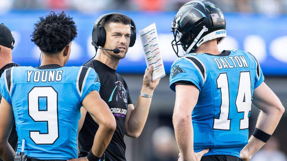 Carolina Panthers coach Dave Canales, center, speaks to Carolina Panthers quarterbacks Andy Dalton (14) and Bryce Young (9) at Bank of America Stadium in Charlotte on Sunday, October 13, 2024.