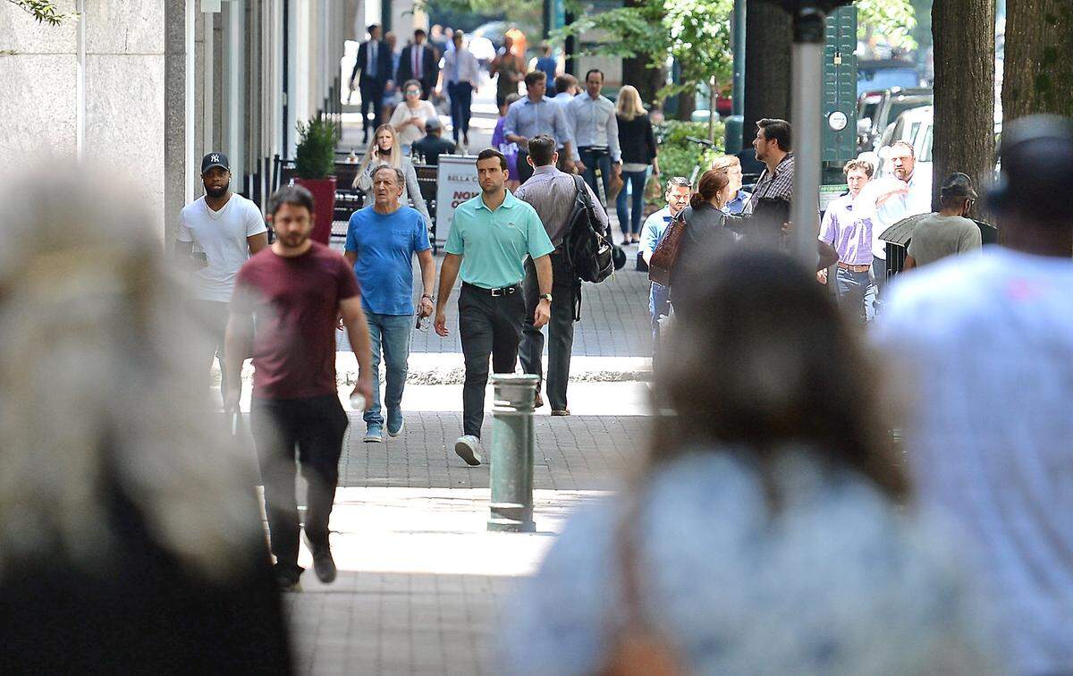 Pedestrians walk along Tryon Street in Charlotte, June 30, 2021. North Carolina last year grew by 112,000 people or about 1%, faster than the national rate, according to new U.S. Census data.