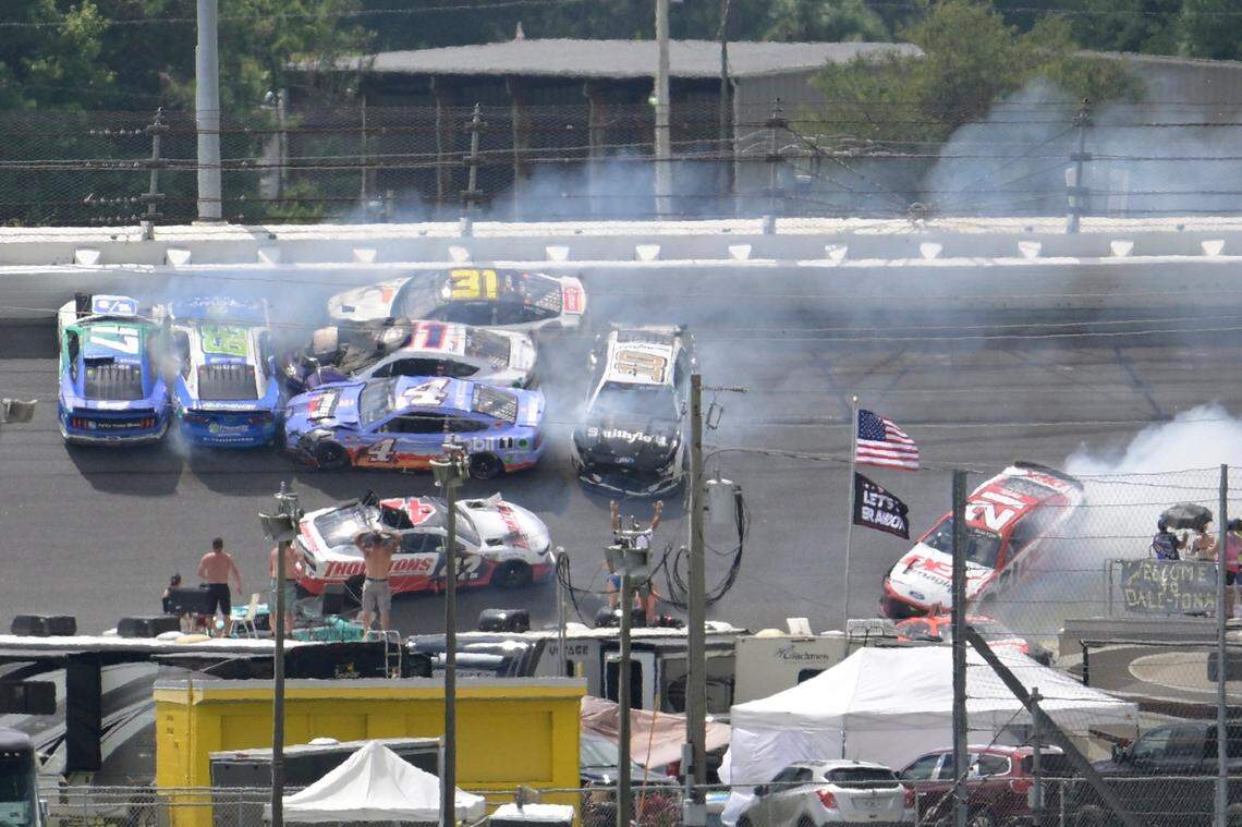 Chris Buescher (17), Daniel Suarez (99), Kevin Harvick (4), Denny Hamlin (11), Justin Haley (31), Ty Dillon (42), Aric Almirola (10) and Harrison Burton (21) are involved in a multi-car accident between turns 1 and 2 during a NASCAR Cup Series auto race at Daytona International Speedway, Sunday, Aug. 28, 2022, in Daytona Beach, Fla. (AP Photo/Phelan M. Ebenhack)