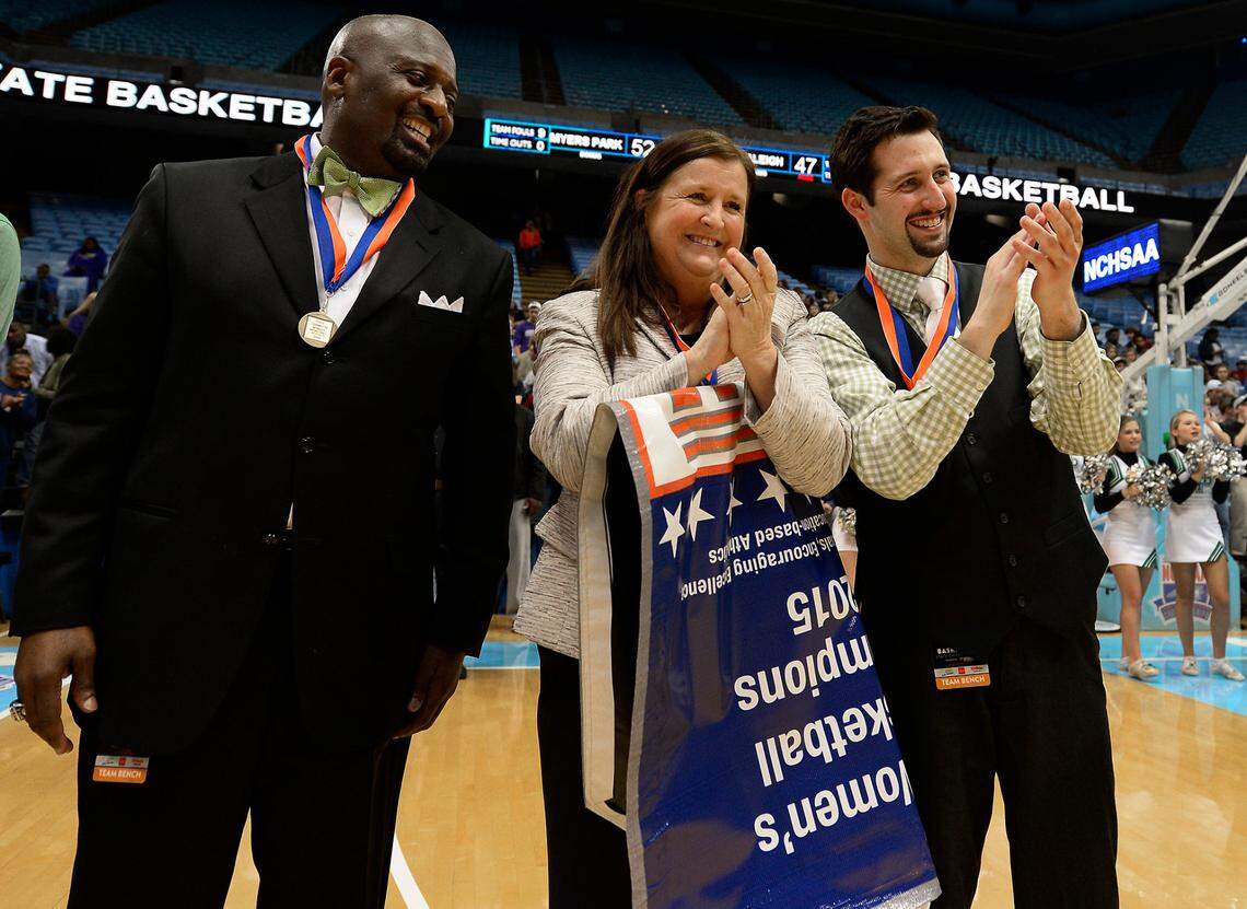 (Center) Myers Park Mustangs head coach Barbara Nelson applauds as players receive their metals following their victory over Southeast Raleigh in the NCHSAA 4A Girls Championship game at the Dean E. Smith Center in Chapel Hill, NC on Saturday March 14, 2015. Myers Park defeated Southeast Raleigh 52-47.