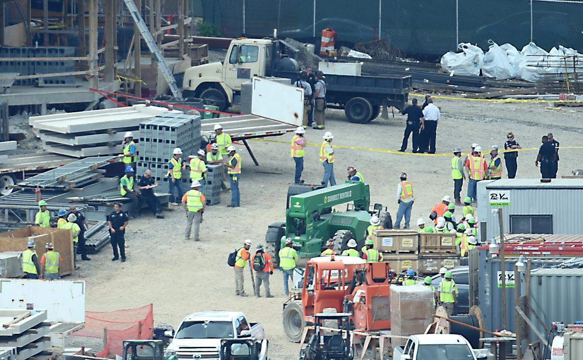 Charlotte Mecklenburg Police officers and construction workers gather at the scene where a worker fell to his death on Wednesday. 
