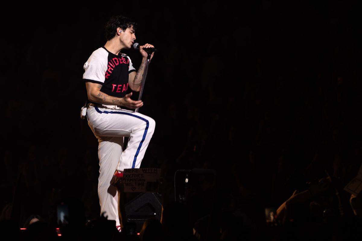 Joe Jonas from The Jonas Brothers sings on a platform at the Spectrum Center in Charlotte, North Carolina on September 30, 2023.