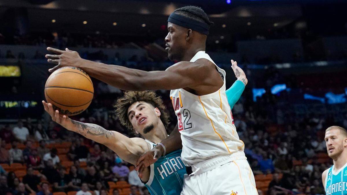 Charlotte Hornets guard LaMelo Ball (1) knocks the ball off the hand of Miami Heat forward Jimmy Butler (22) during the first half of an NBA basketball game Saturday, Nov. 12, 2022, in Miami. (AP Photo/Marta Lavandier)