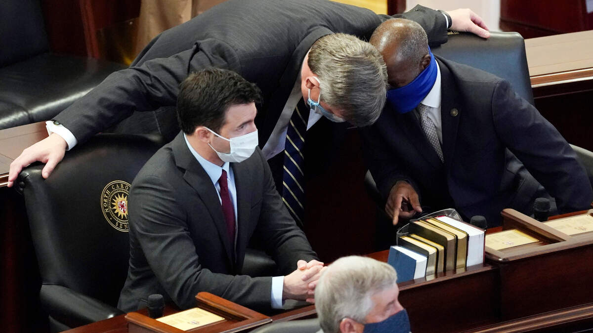 Sen. Mike Woodard, D-Durham, speaks with Sen. Ben Clark, D-Hoke, right, and Sen. Jeff Jackson, D-Mecklenburg in the Senate chamber during the opening session of the North Carolina General Assembly in Raleigh, N.C., Wednesday, Jan. 13, 2021.