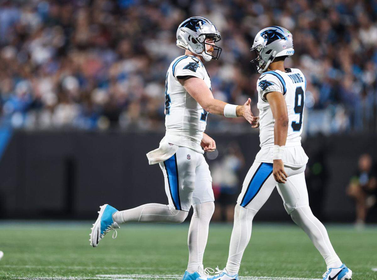 Carolina Panthers quarterback Bryce Young, right gives Andy Dalton a low five as they trade positions on the field at the Bank of America Stadium in Charlotte, N.C., on Monday, September 18, 2023.