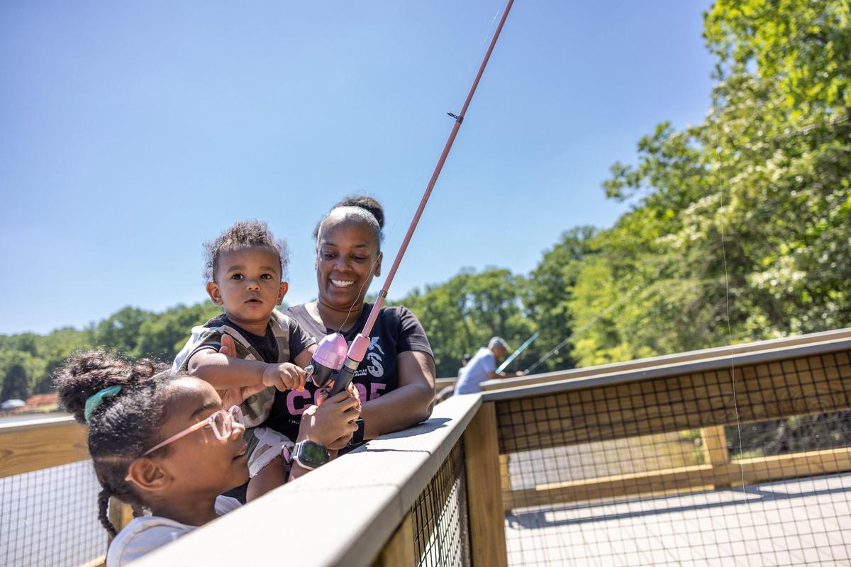 Lorraine Grunhut, right, fishes with her children, Amina, left, and Asim at Mountain Creek Park on opening day in Sherrills Ford, N.C., on Saturday, June 18, 2022. The new park offers a fishing pier and a paddle launch, among many other amenities.
