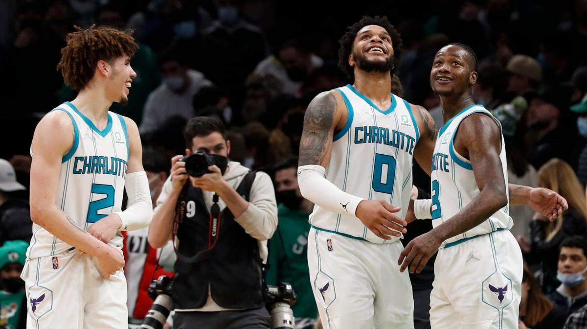 Charlotte Hornets’ LaMelo Ball, left, Miles Bridges (0) and Terry Rozier celebrate after they defeated the Boston Celtics in an NBA basketball game Wednesday, Jan. 19, 2022, in Boston. (AP Photo/Winslow Townson)