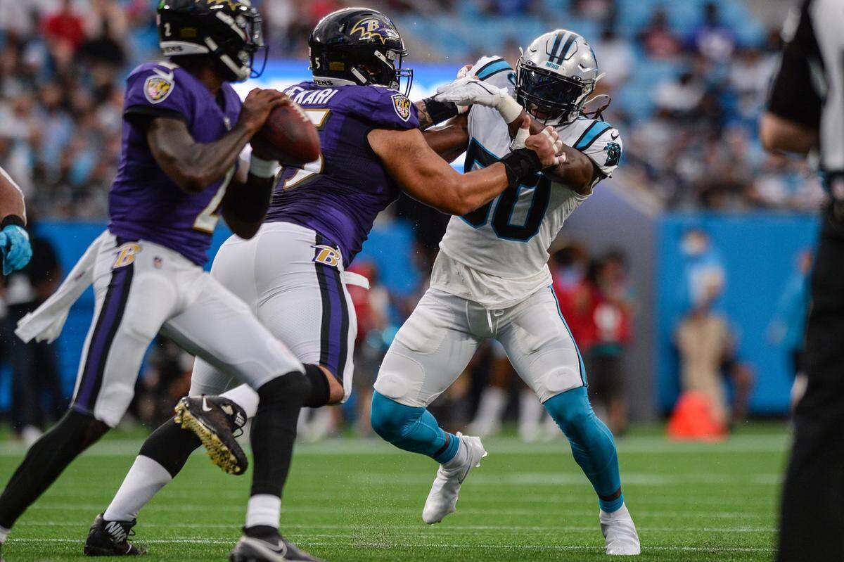 Panthers linebacker Julian Stafford, right, fights off Ravens offensive lineman Patrick Mekari, center, during the pre-season game on Saturday, August 21, 2021 at Bank of America Stadium.