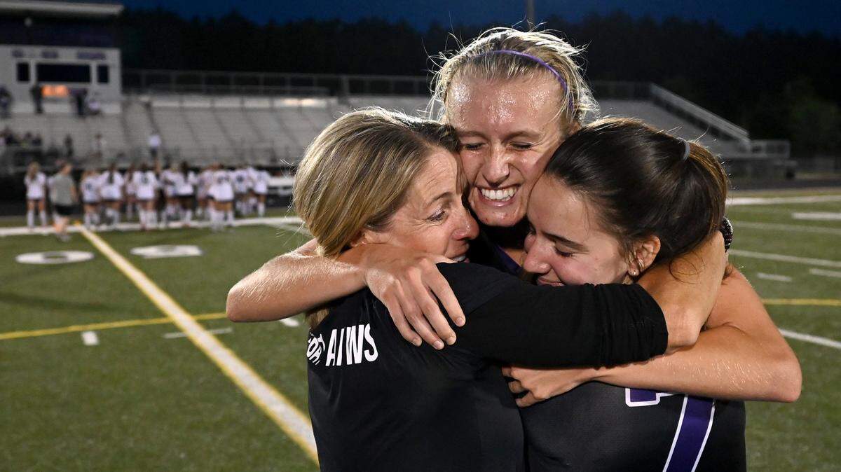Ardrey Kell head girls soccer head coach Kim Montgomery, left, her daughter Carly Montgomery, center and Ellie Herrmann, right, celebrate the team’s 2-1 victory over Hough on Thursday, May 26, 2022. The teams were competing in a state quarterfinals girls soccer match.