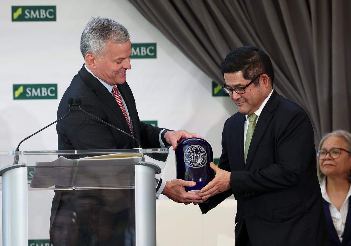 North Carolina Governor Josh Stein, left, presents Hiro Otsuka, Chief Executive Officer, SMBC Americas, right, with a gift following the announcement that the Japanese bank will be making Charlotte its second U.S. headquarters on Tuesday, April 7, 2026. In addition to the second headquarters, the bank has committed to add 2,000 high-paying financial services jobs from 2028 through 2032.