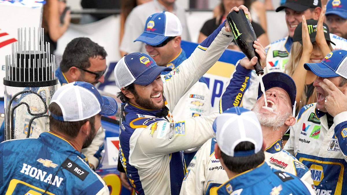 NASCAR driver Chase Elliott, center, celebrates winning the Bank of America ROVAL 400 at Charlotte Motor Speedway on Sunday, September 29, 2019 by pouring champagne into the mouth of a crew member in Victory Lane.