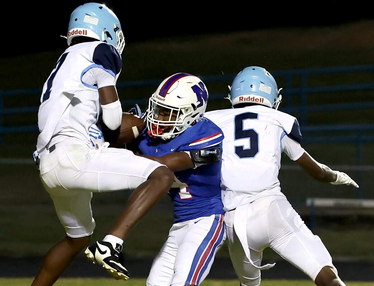 Huss Huskies Nazire Davis, left, intercepts a North Meck pass attempt to wide receiver Bryant White, center, during second quarter action at North Meck High on Friday, September 5, 2025.