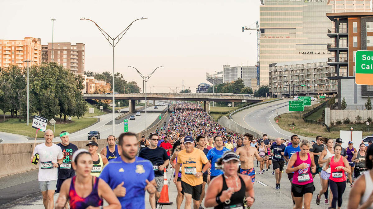Around the Crown 10K runners crowd Interstate 277 in the 2019 race.