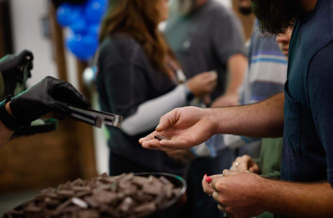 Non-infused chocolates and gummies are passed to people waiting in line for the 10:00 a.m. opening of the Great Smokies Cannabis Company dispensary in Cherokee, NC on Saturday, September 7, 2024.