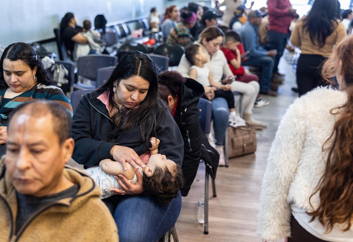 Honduran families sit in a waiting room at the Honduran Consulate in Charlotte on Friday. Consul General Enrique Flores Dubon says more Hondurans are trying to get their kids citizenship in Honduras after President Trump returned to office and that more are returning home.