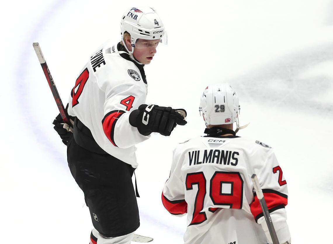 Charlotte Checkers Jack Devine, left, reaches out to bump fists with teammate Sandis Villains, right, following Devine’s goal during second period action against the Iowa Wild on Friday, October 17, 2025 at Bojangles Coliseum in Charlotte, NC. 