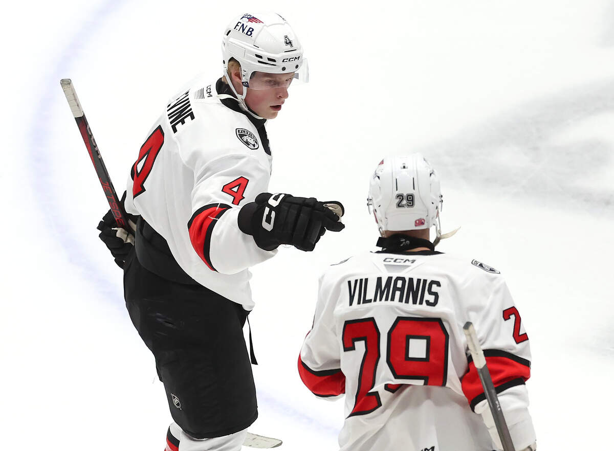 Charlotte Checkers Jack Devine, left, reaches out to bump fists with teammate Sandis Villains, right, following Devine’s goal during second period action against the Iowa Wild on Friday, October 17, 2025 at Bojangles Coliseum in Charlotte, NC.
