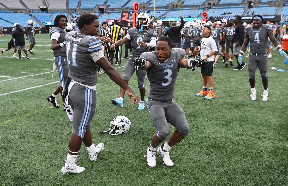 Members of the Hough Huskies celebrate their 14-10 victory over the South Pointe Stallions during the Keep Pounding Classic at Bank of America Stadium in Charlotte, NC on Friday, Aug. 22, 2025.