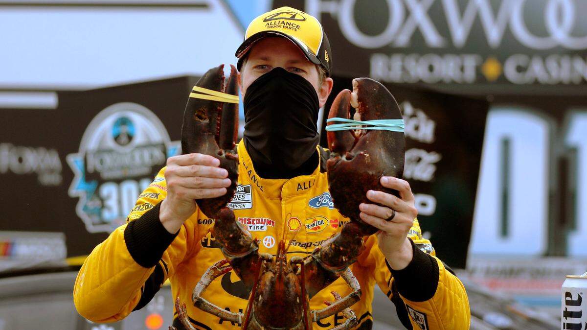 Driver Brad Keselowski holds a giant lobster to celebrate his victory in a NASCAR Cup Series auto race, Sunday, Aug. 2, 2020, at the New Hampshire Motor Speedway in Loudon, N.H. (AP Photo/Charles Krupa)