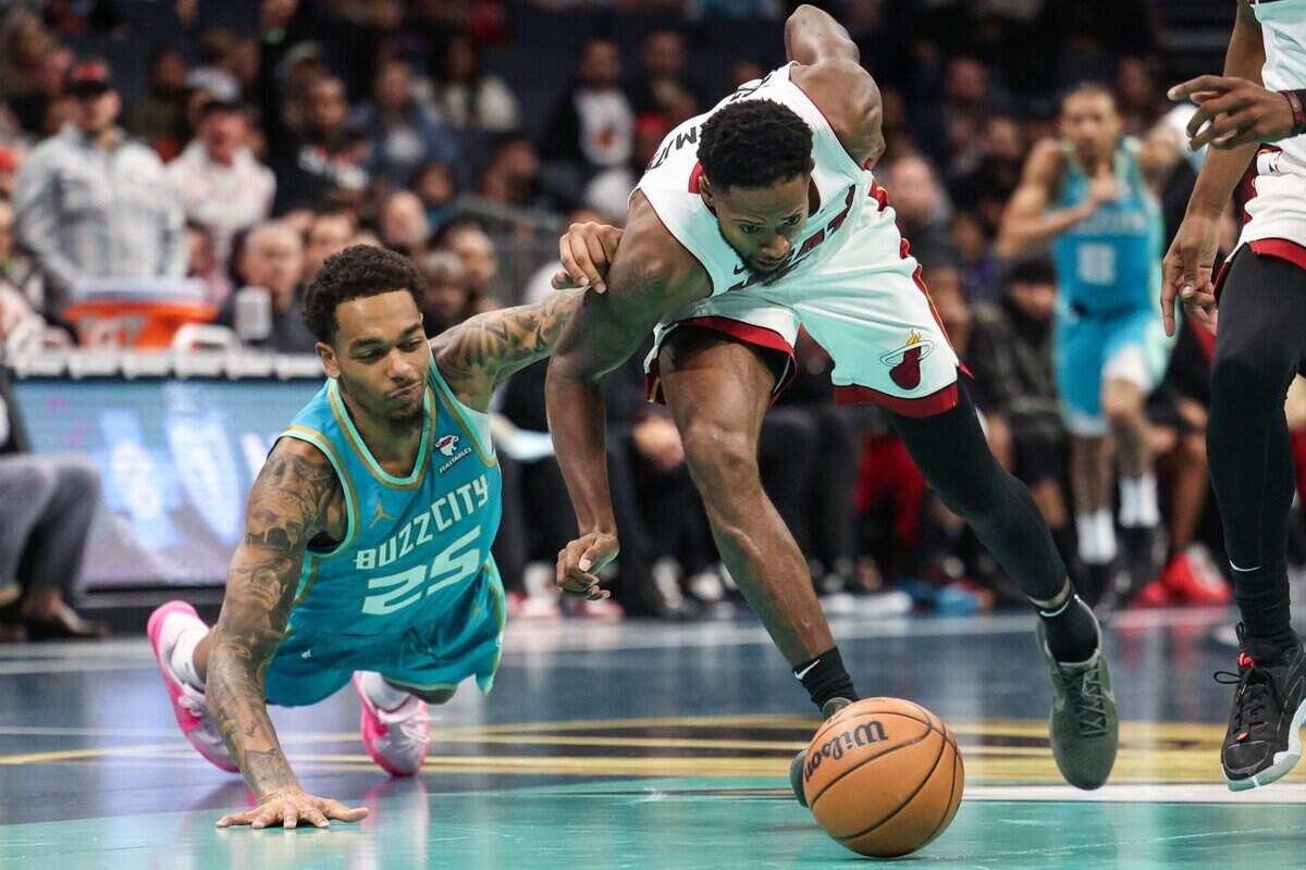 Hornets forward P.J. Washington (25) and Heat forward Haywood Highsmith (24) fight for a loose ball during the game at Spectrum Center on Tuesday, November 14, 2023 in Charlotte, NC.