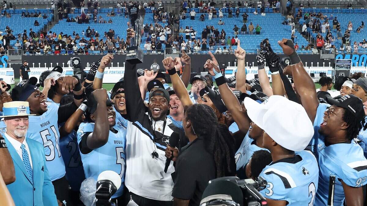Hough Huskies head coach David Baker, center, and his team celebrate their 35-10 victory over Cardinal Gibbons in the Keep Pounding High School Classic at Bank of America Stadium on Saturday, August 29, 2026.