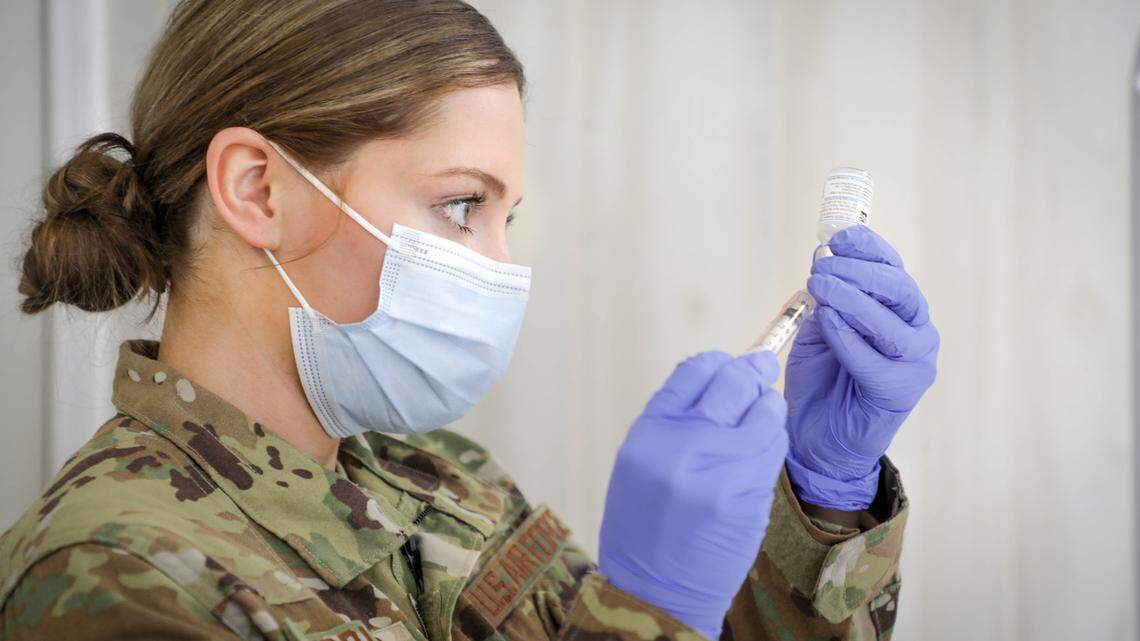 North Carolina National Guard Airman First Class Emily Riddles prepares a COVID-19 vaccine shot at Central Prison in Raleigh. Twenty-five members of the guard are deploying to Alamance Regional Medical Center to help the staff get through the surge in COVID-19 cases.