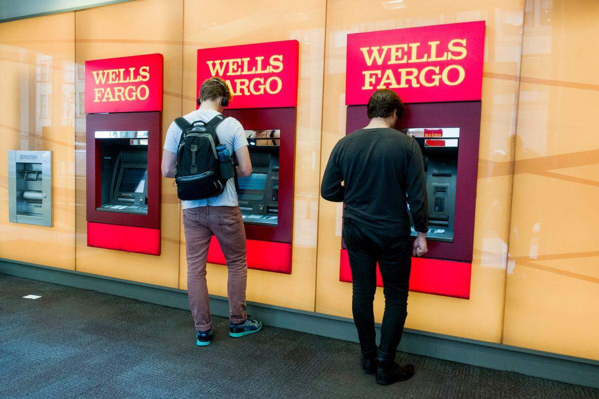 FILE — Patrons use ATMs at a Wells Fargo bank in New York, Sept. 7, 2017. Wells Fargo&nbsp;agreed to&nbsp;pay $575&nbsp;million&nbsp;to resolve investigations by all 50 states and Washington, D.C., that began&nbsp;after federal regulators revealed in September 2016&nbsp;that employees had for years&nbsp;opened millions of unauthorized bank accounts in customers’ names. (Devin Yalkin/The New York Times)