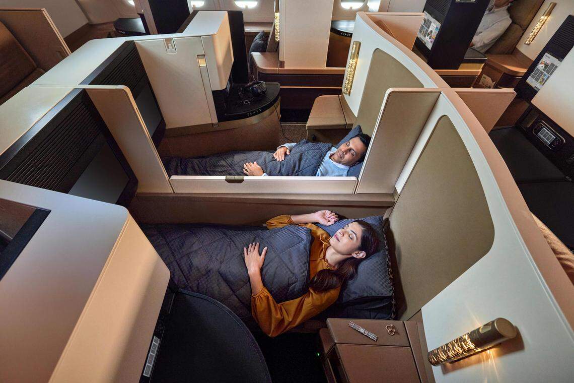 A couple enjoys business class service on a Etihad Airways flight.