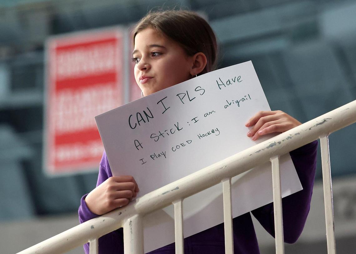 Charlotte Checkers fan Abigail Nava glances out toward the ice with one request to a player prior to action against the Cleveland Monsters at Bojangles Coliseum in Charlotte, NC on Friday, October 18, 2024.