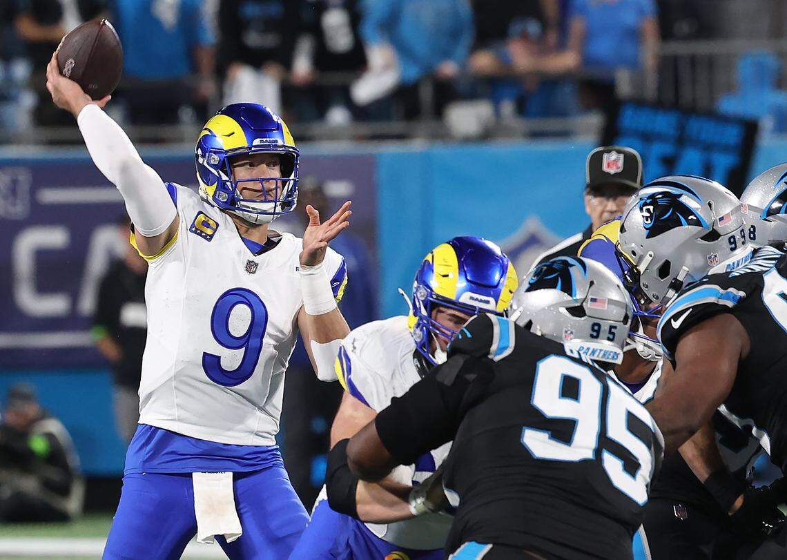 Los Angeles Rams quarterback Matthew Stafford, left, drops back to pass over the Carolina Panthers defense during action at Bank of America Stadium on Saturday, January 10, 2026. The Rams defeated the Panthers 34-31.