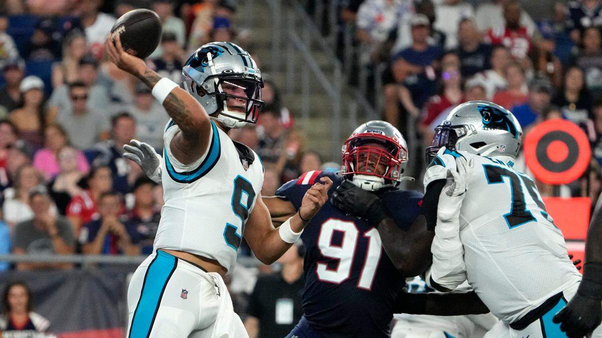 Carolina Panthers quarterback Matt Corral (9) passes under pressure from New England Patriots defensive end Deatrich Wise Jr. (91) during the first half of a preseason NFL football game Friday, Aug. 19, 2022, in Foxborough, Mass. (AP Photo/Michael Dwyer)