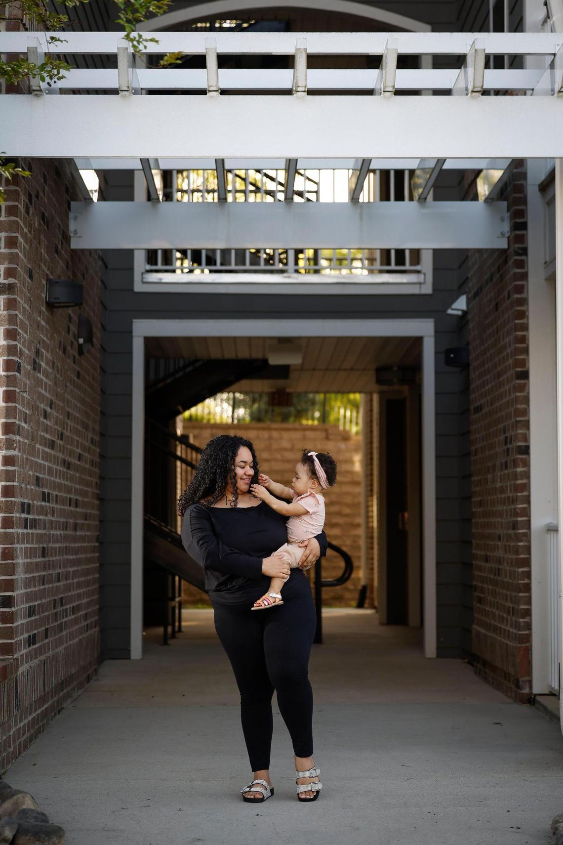 Rochelle Vassar with her 1-year-old daughter Meadow outside of their rented apartment in Huntersville.