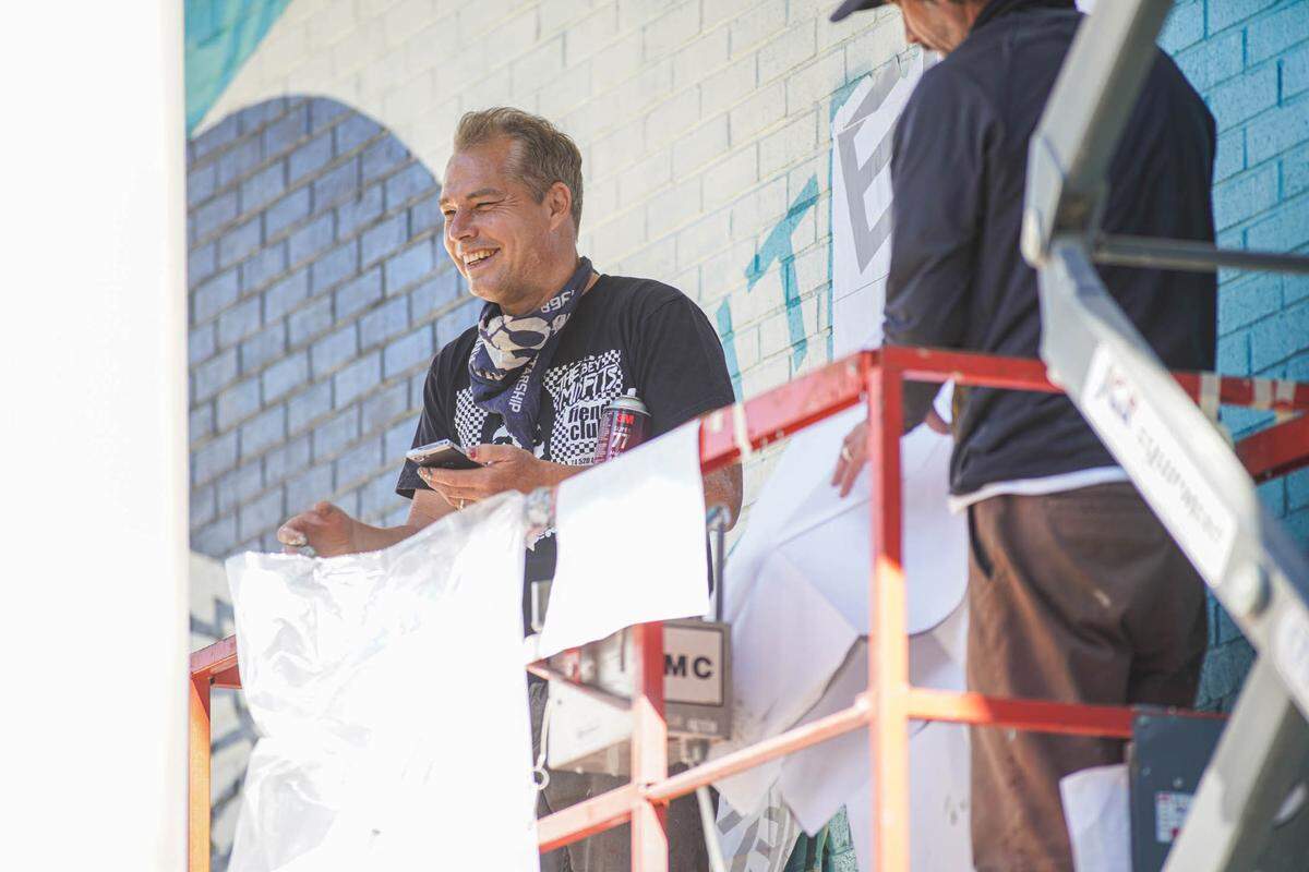 Shepard Fairey takes a break from painting a mural at Queens University of Charlotte to address the small crowd of bystanders on Thursday, Oct. 21.