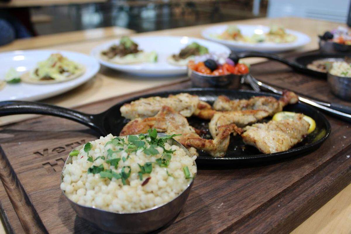Picasso Mediterranean’s oregano chicken is served with couscous and a Mediterranean side salad.