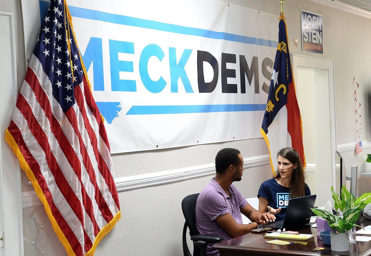 Erik Daniels (left), Mecklenburg County Democratic Party executive director, 29 and Jennifer Gaddy, MCDP second vice-chair, confer at party headquarters.