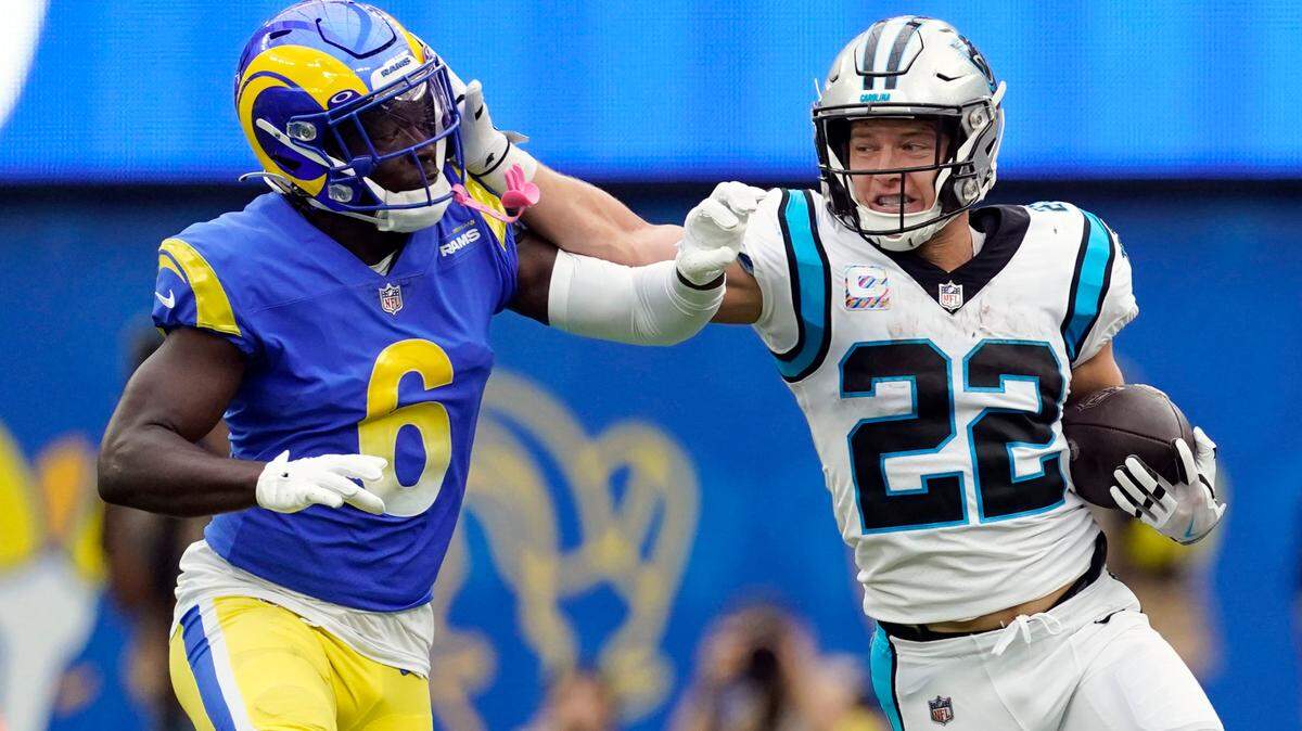 Carolina Panthers running back Christian McCaffrey (22) stiff-arms Los Angeles Rams cornerback Derion Kendrick (6) during the first half of an NFL football game Sunday, Oct. 16, 2022, in Inglewood, Calif. (AP Photo/Ashley Landis)