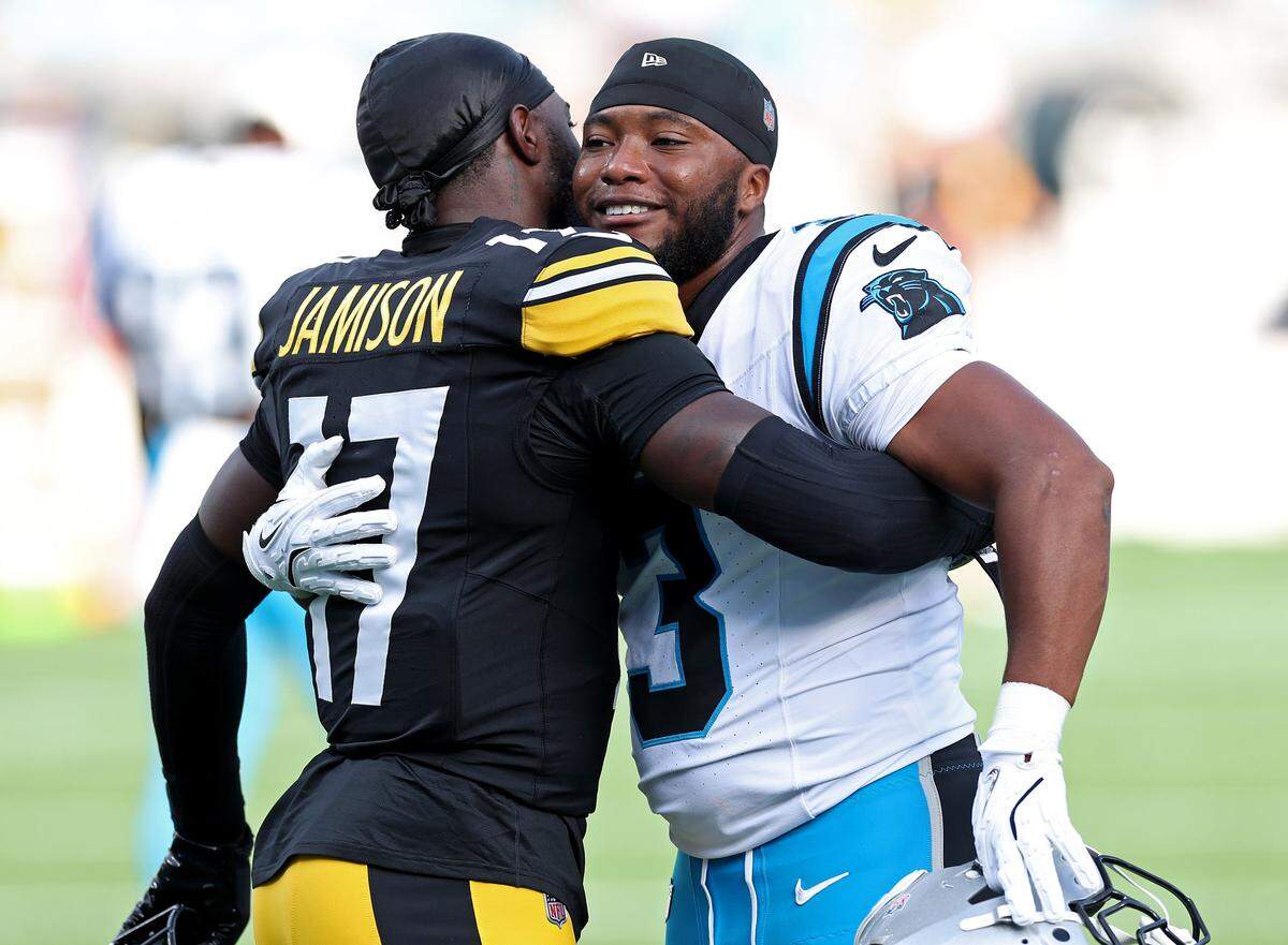 Pittsburgh Steelers cornerback D'Shawn Jamison, left and Carolina Panthers running back Raheem Blackshear, right, hug prior to a preseason game at Bank of America Stadium in Charlotte, NC on Thursday, August 21, 2025.