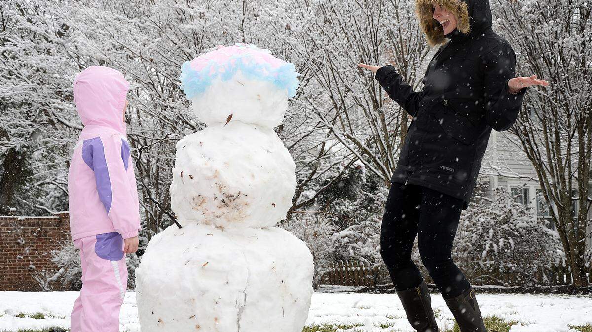 Feb. 11, 2014. Jordan Larson-Horstman and her daughter Jane, 4, build a snowman on Queens Rd. Tuesday, using a tutu as a hat.