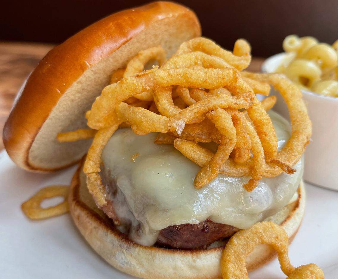 The Crepe Cellar Burger is covered with Gruyere, onion straws and garlic aioli on a brioche bun.