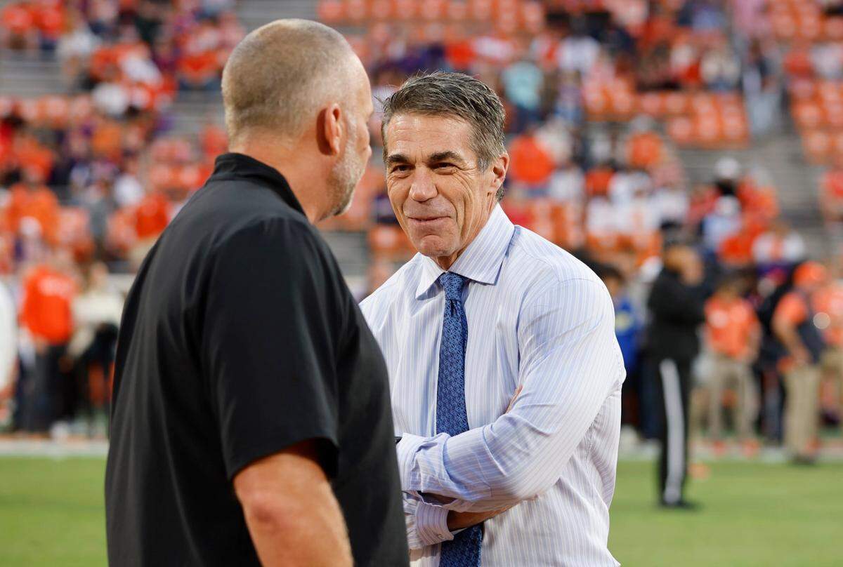 N.C. State head coach Dave Doeren (left) talks with ESPN’s Chris Fowler before N.C. State’s game against Clemson at Memorial Stadium in Clemson, S.C., on Oct. 1, 2022.